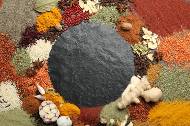 Photo of Different aromatic spices on dark textured table, top view. Space for text