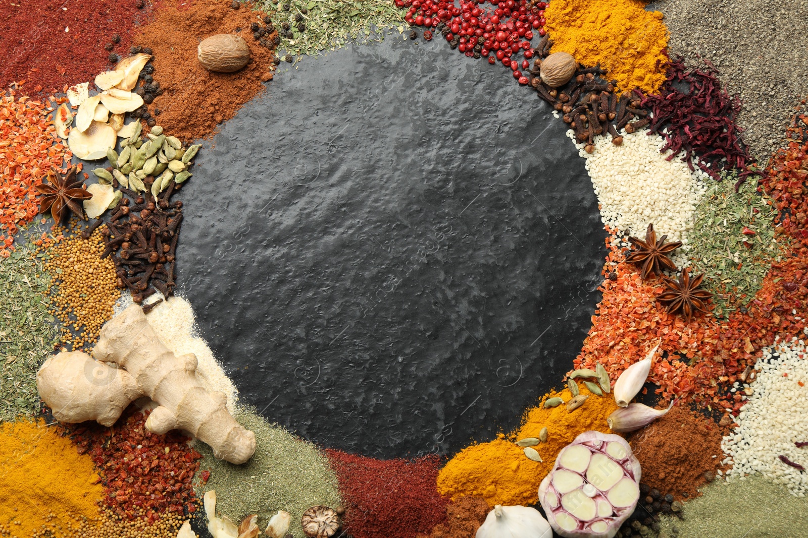 Different aromatic spices on dark textured table, top view. Space for text Photo of Different aromatic spices on dark textured table, top view. Space for text