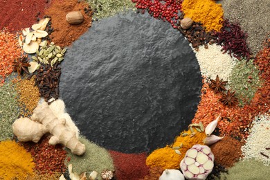 Photo of Different aromatic spices on dark textured table, top view. Space for text