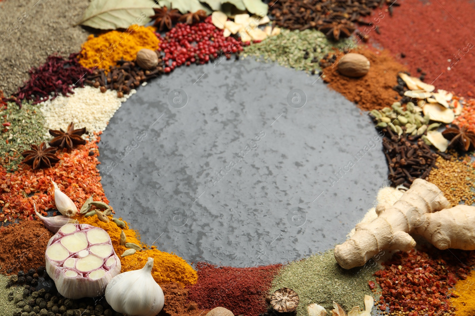Different aromatic spices on gray textured table, closeup. Space for text Photo of Different aromatic spices on gray textured table, closeup. Space for text
