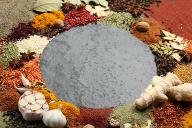 Photo of Different aromatic spices on gray textured table, closeup. Space for text