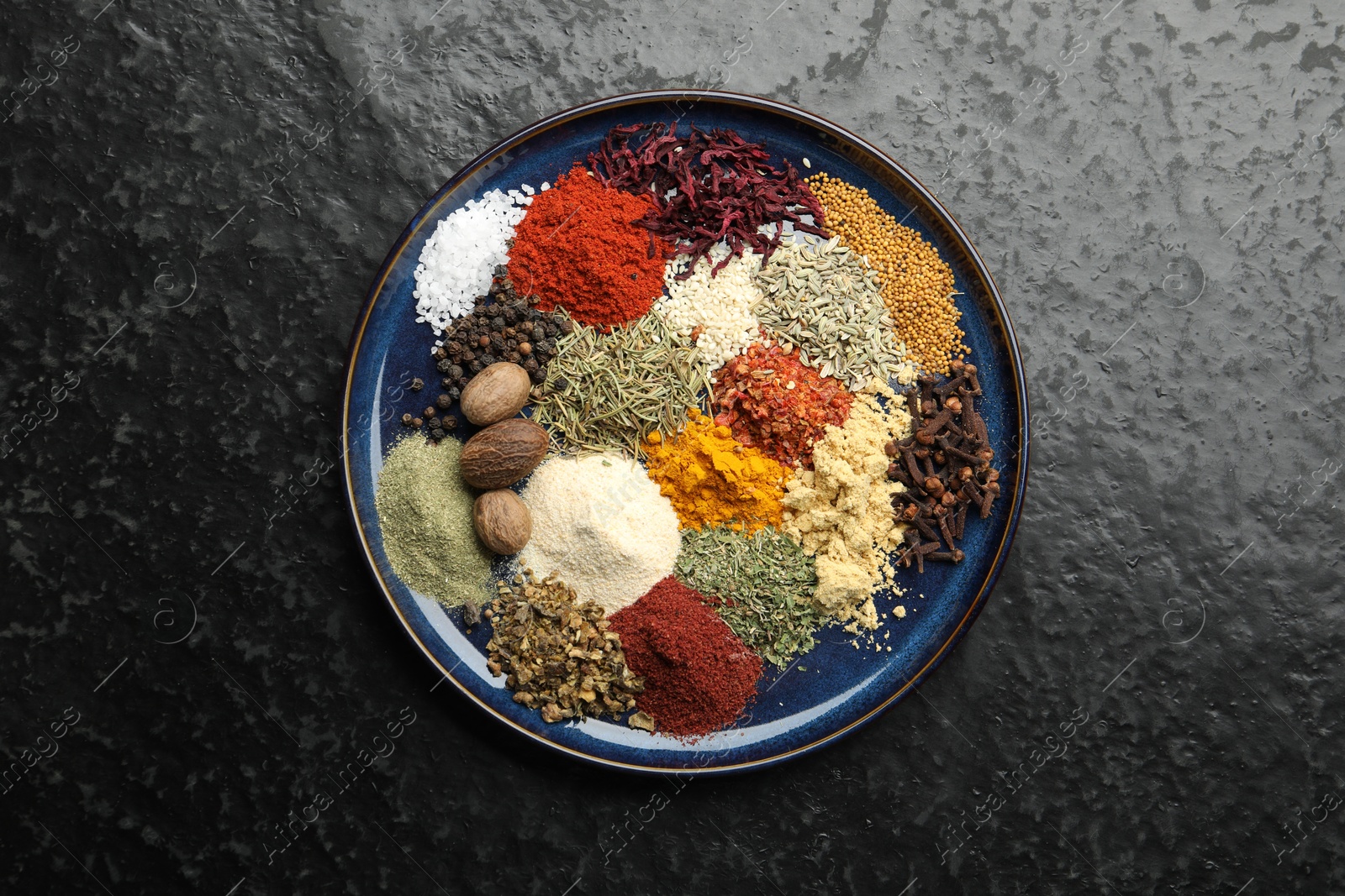 Different aromatic spices on dark textured table, top view Photo of Different aromatic spices on dark textured table, top view