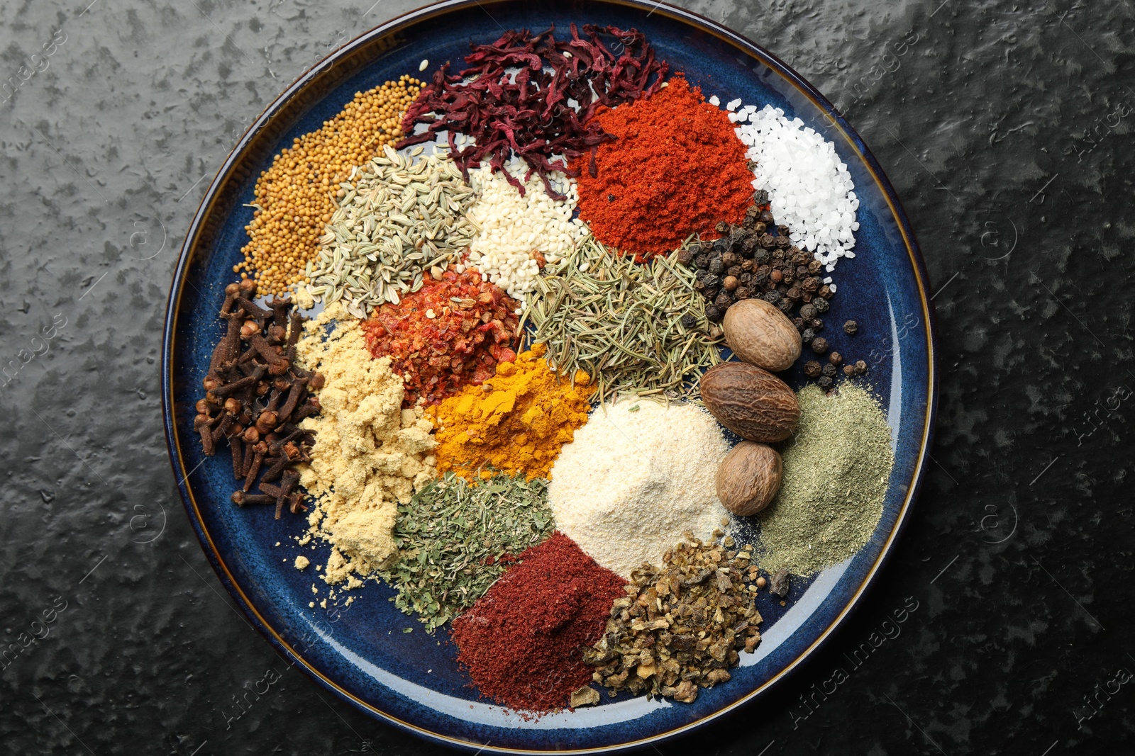 Different aromatic spices on dark textured table, top view Photo of Different aromatic spices on dark textured table, top view