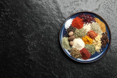 Photo of Different aromatic spices on dark textured table, top view. Space for text