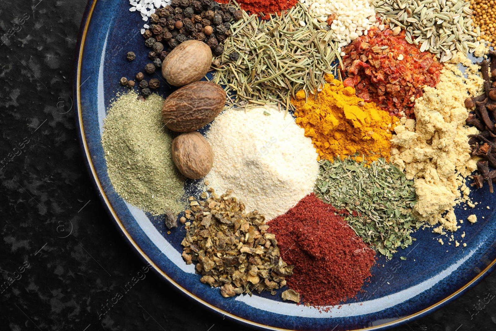 Different aromatic spices on dark textured table, top view Photo of Different aromatic spices on dark textured table, top view