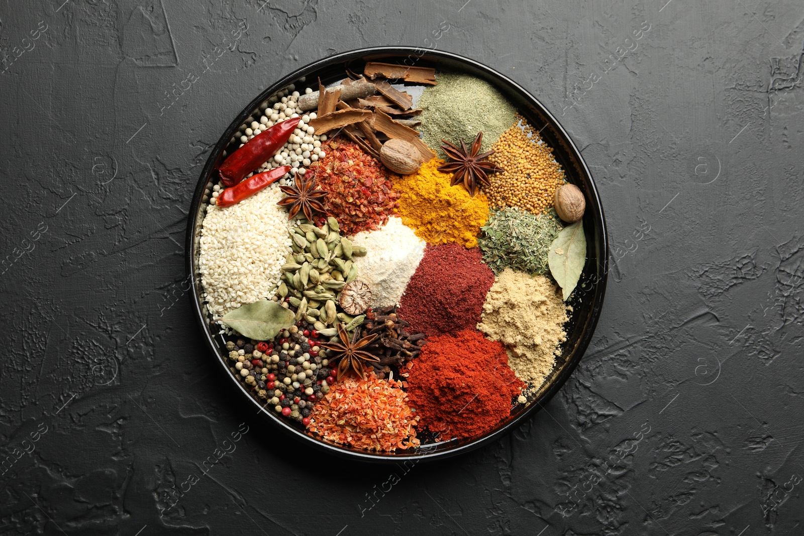 Different aromatic spices on dark textured table, top view Photo of Different aromatic spices on dark textured table, top view