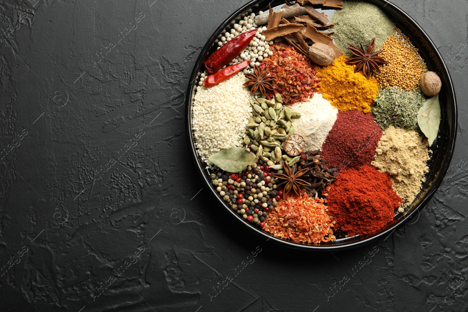 Different aromatic spices on dark textured table, top view. Space for text Photo of Different aromatic spices on dark textured table, top view. Space for text