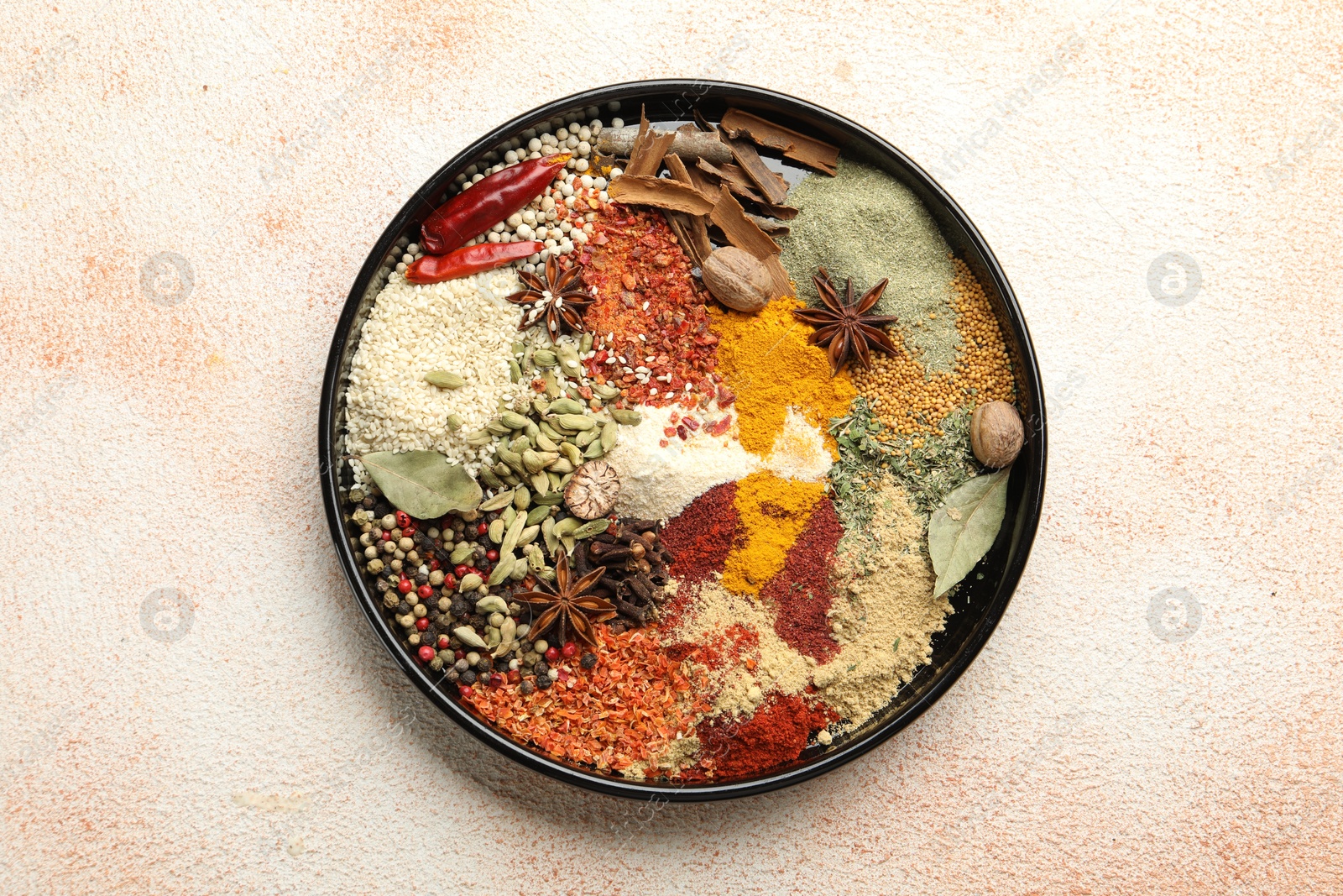 Different aromatic spices on beige textured table, top view Photo of Different aromatic spices on beige textured table, top view