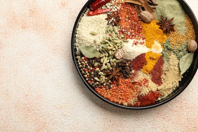 Photo of Different aromatic spices on beige textured table, top view. Space for text