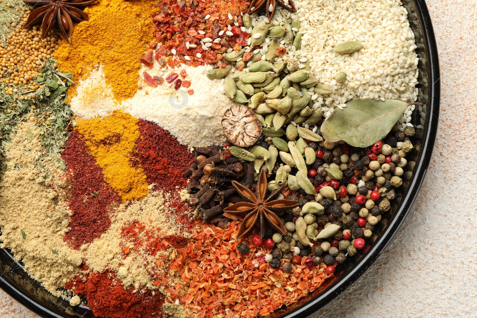 Different aromatic spices on beige textured table, top view Photo of Different aromatic spices on beige textured table, top view