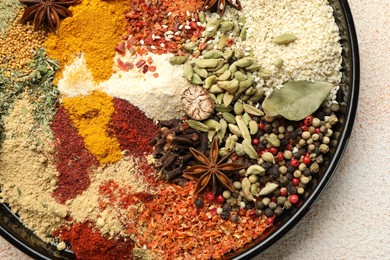 Photo of Different aromatic spices on beige textured table, top view