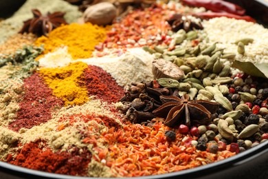 Photo of Many different aromatic spices on plate, closeup