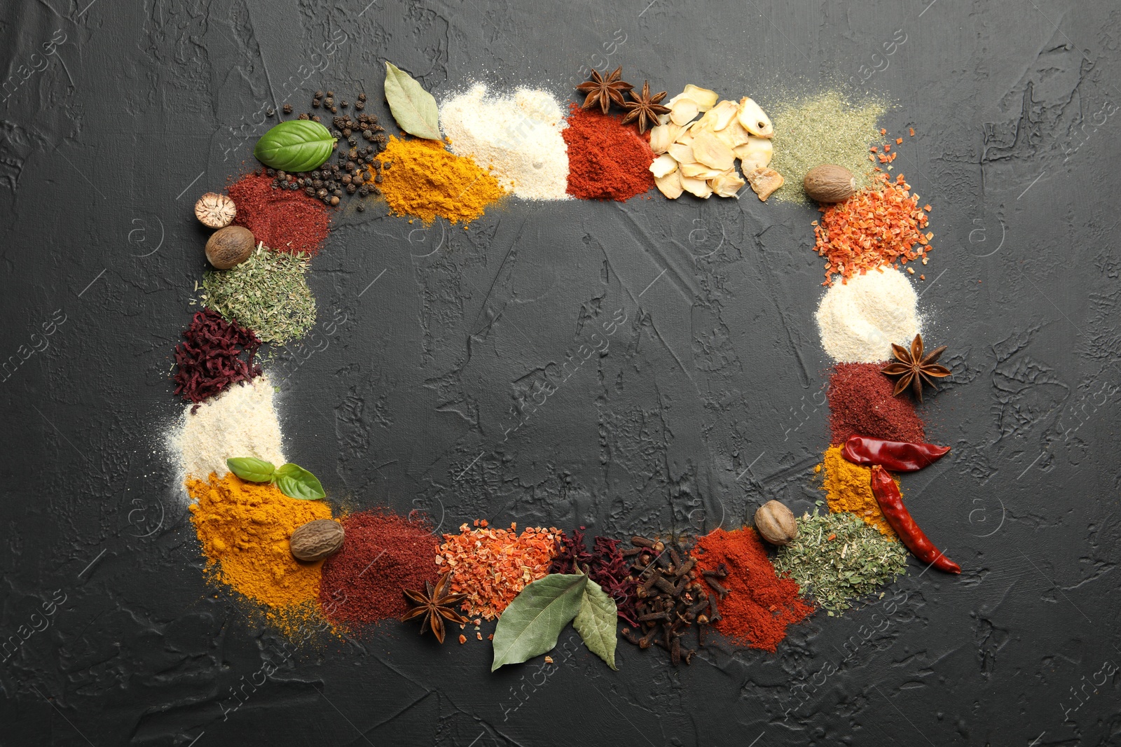 Different aromatic spices on dark textured table, top view. Space for text Photo of Different aromatic spices on dark textured table, top view. Space for text