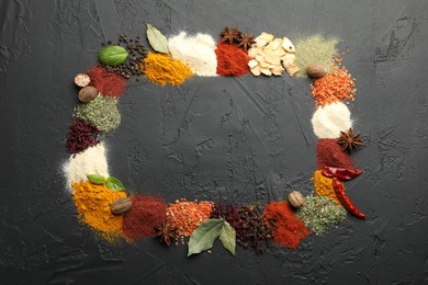 Photo of Different aromatic spices on dark textured table, top view. Space for text