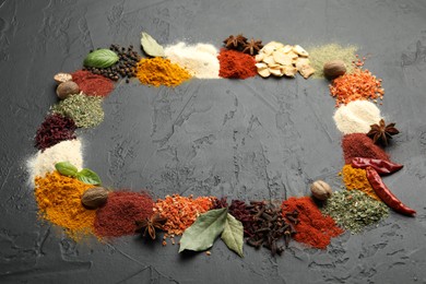 Photo of Different aromatic spices on dark textured table, space for text