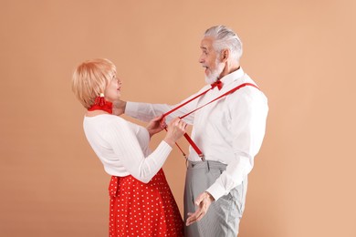 Photo of Lovely senior couple together on light brown background