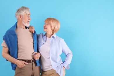 Photo of Lovely senior couple together on light blue background, space for text