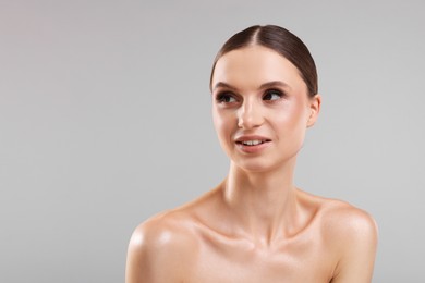 Photo of Portrait of beautiful young woman on gray background, space for text