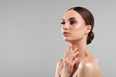 Photo of Portrait of beautiful young woman on gray background, space for text