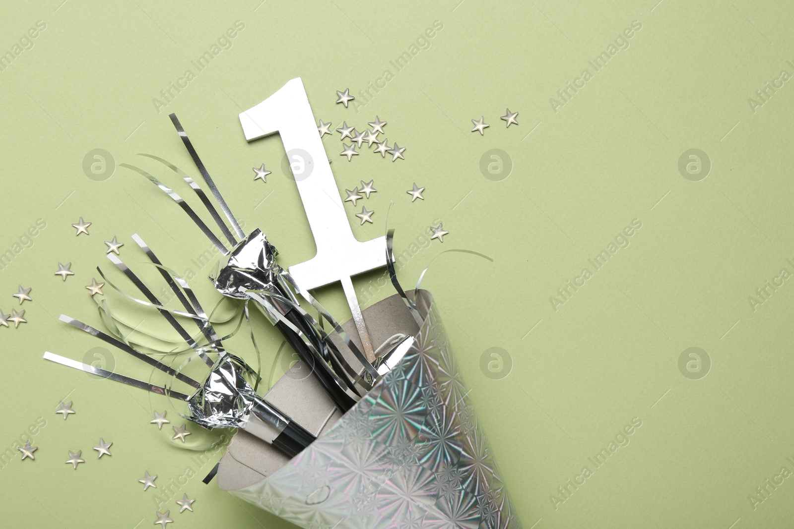Party hat, blowers, topper and confetti on light green background, top view. Space for text Photo of Party hat, blowers, topper and confetti on light green background, top view. Space for text