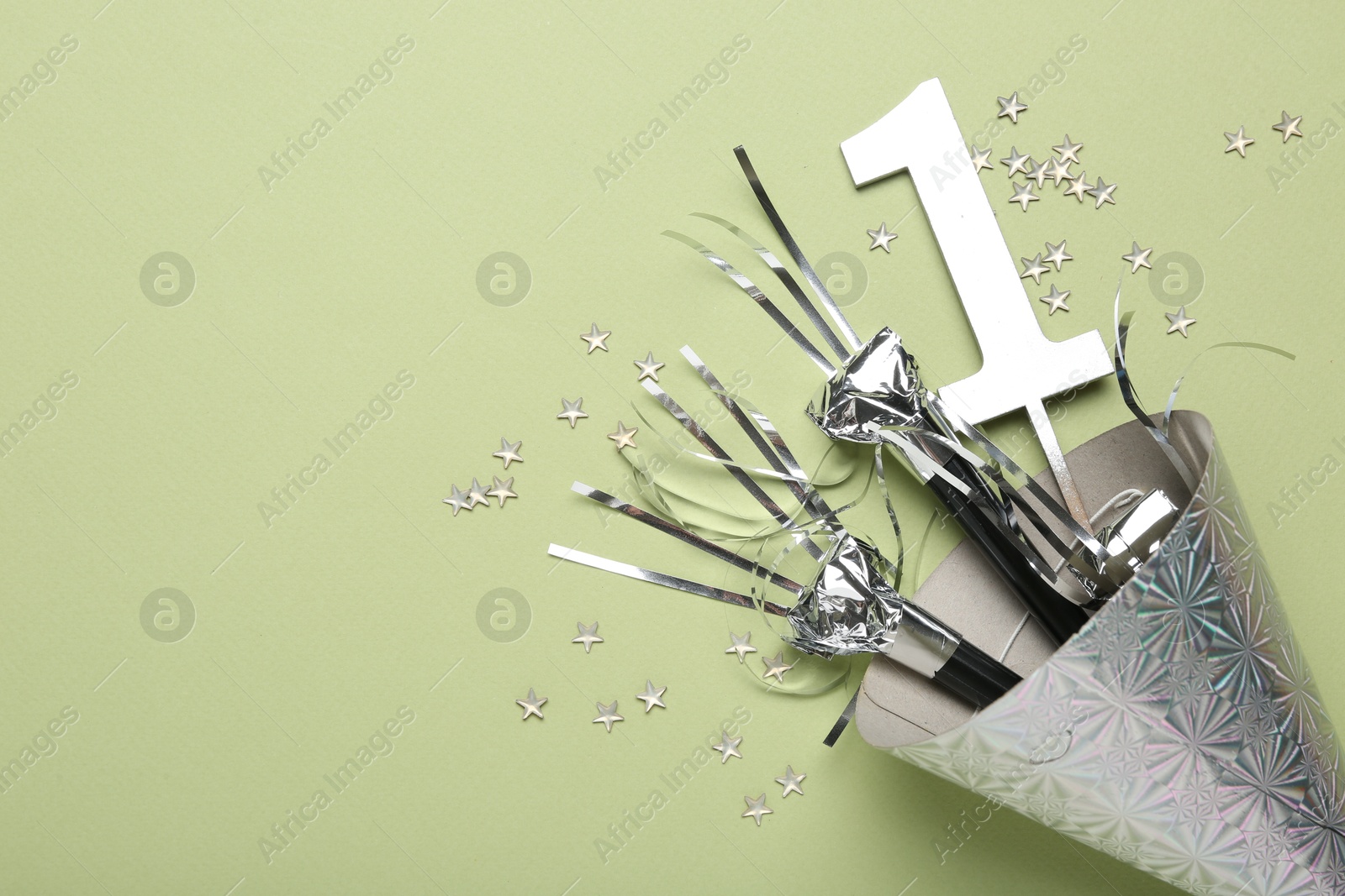 Party hat, blowers, topper and confetti on light green background, top view. Space for text Photo of Party hat, blowers, topper and confetti on light green background, top view. Space for text