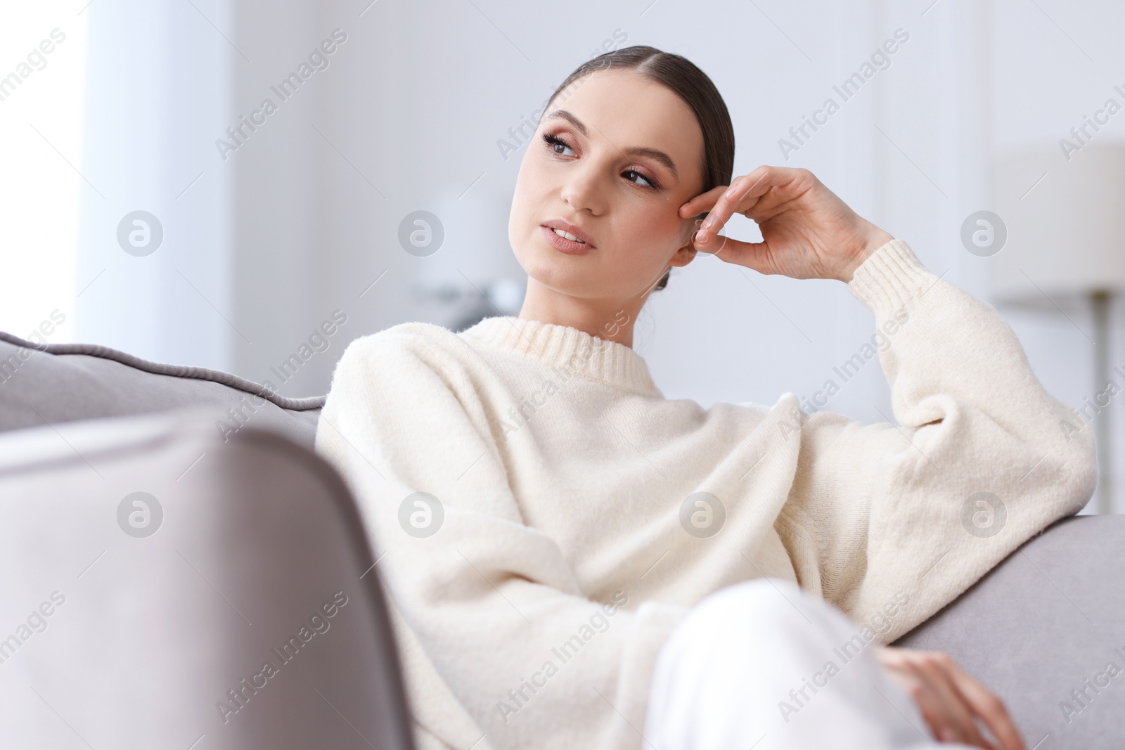 Portrait of beautiful young woman on sofa at home Photo of Portrait of beautiful young woman on sofa at home