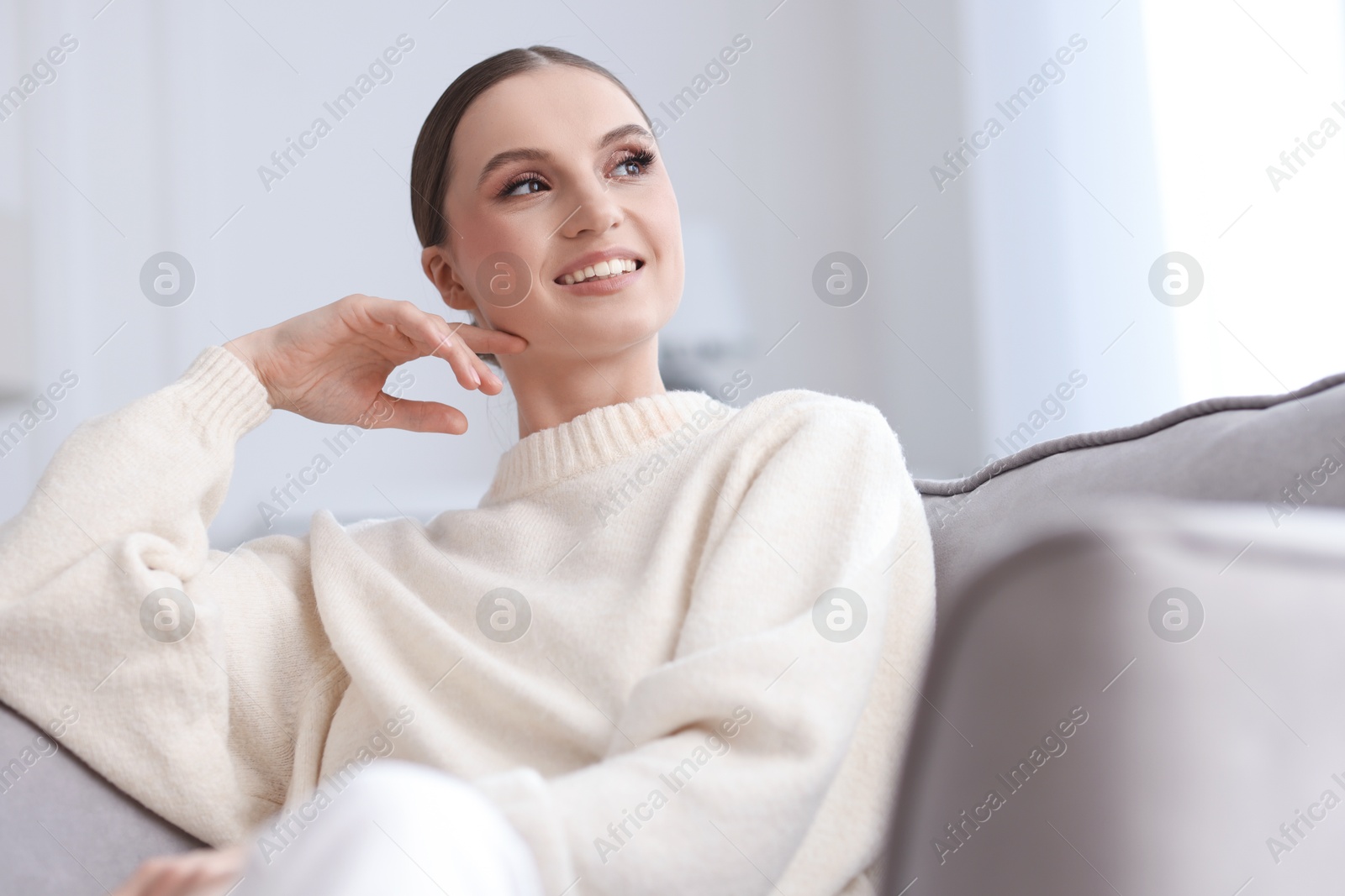 Portrait of beautiful young woman on sofa at home Photo of Portrait of beautiful young woman on sofa at home