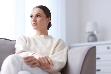 Photo of Portrait of beautiful young woman on sofa at home
