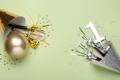 Photo of Flat lay composition with party hats and blowers on light green background