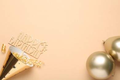 Photo of Party hat, topper, streamers and balloons on beige background, flat lay. Space for text