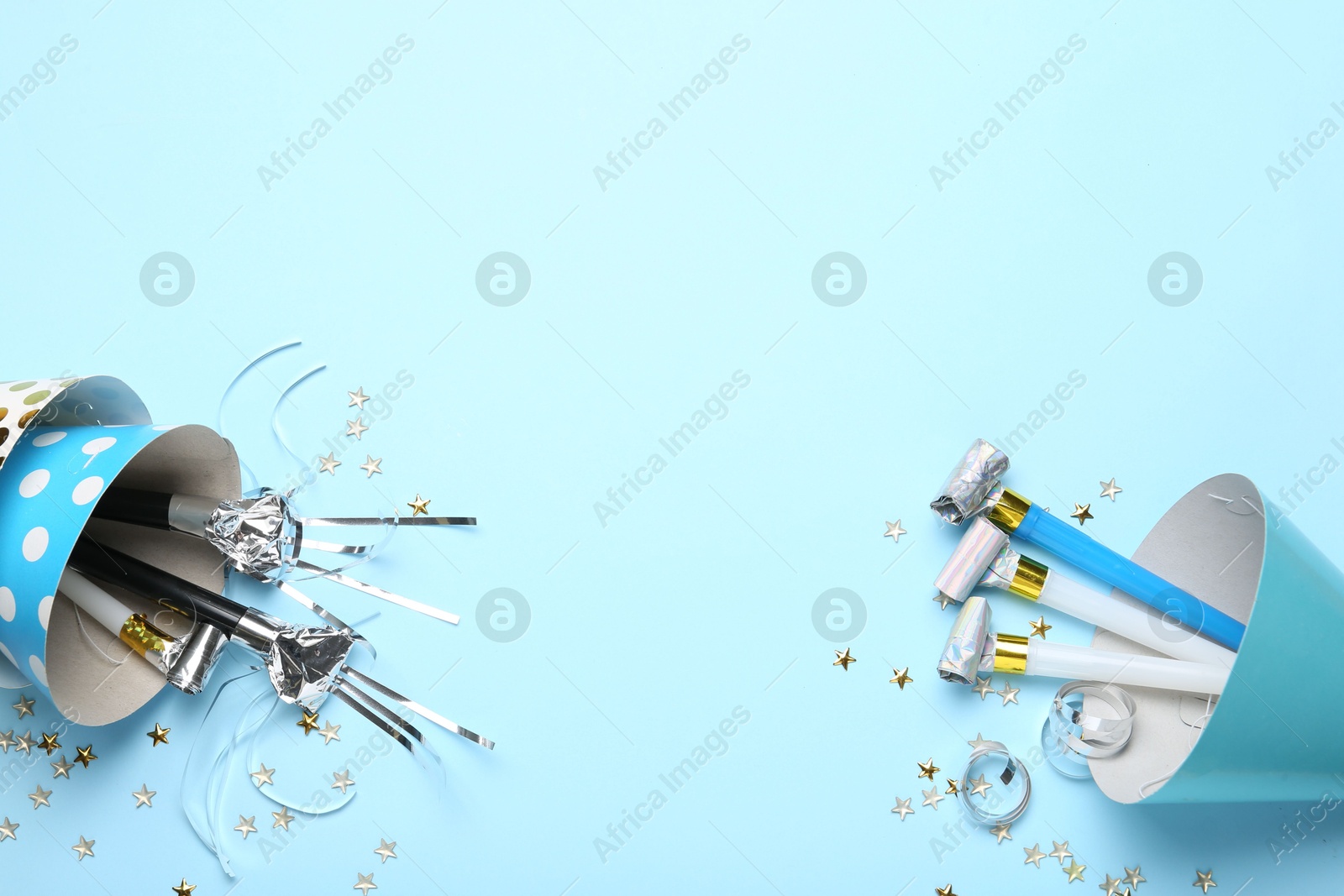 Flat lay composition with party hats and confetti on light blue background. Space for text Photo of Flat lay composition with party hats and confetti on light blue background. Space for text