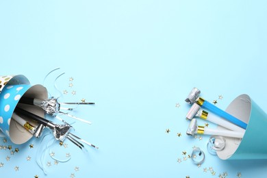 Photo of Flat lay composition with party hats and confetti on light blue background. Space for text