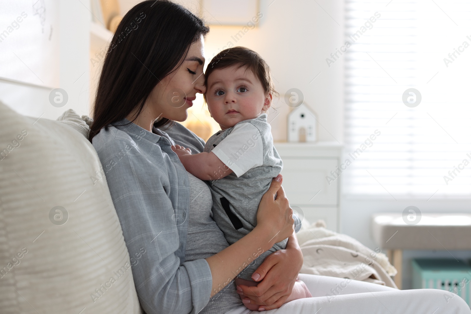 Mother with her cute baby on sofa at home Photo of Mother with her cute baby on sofa at home