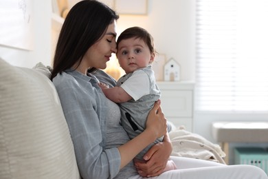 Photo of Mother with her cute baby on sofa at home