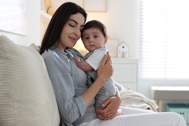 Photo of Mother with her cute baby on sofa at home