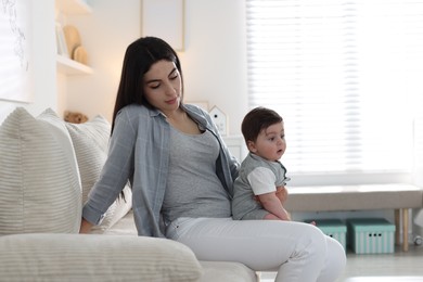 Photo of Woman suffering from postpartum depression with her little baby on sofa at home. Space for text