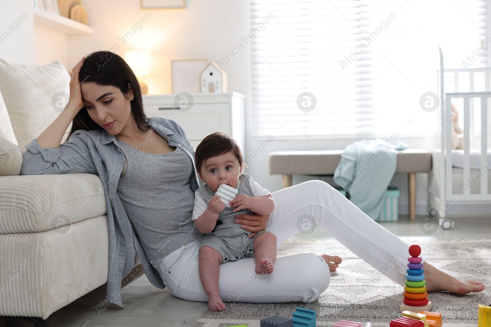 Woman suffering from postpartum depression with her little baby at home. Space for text Photo of Woman suffering from postpartum depression with her little baby at home. Space for text