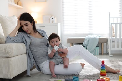Photo of Woman suffering from postpartum depression with her little baby at home. Space for text