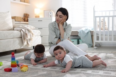 Photo of Woman suffering from postpartum depression with her little children at home
