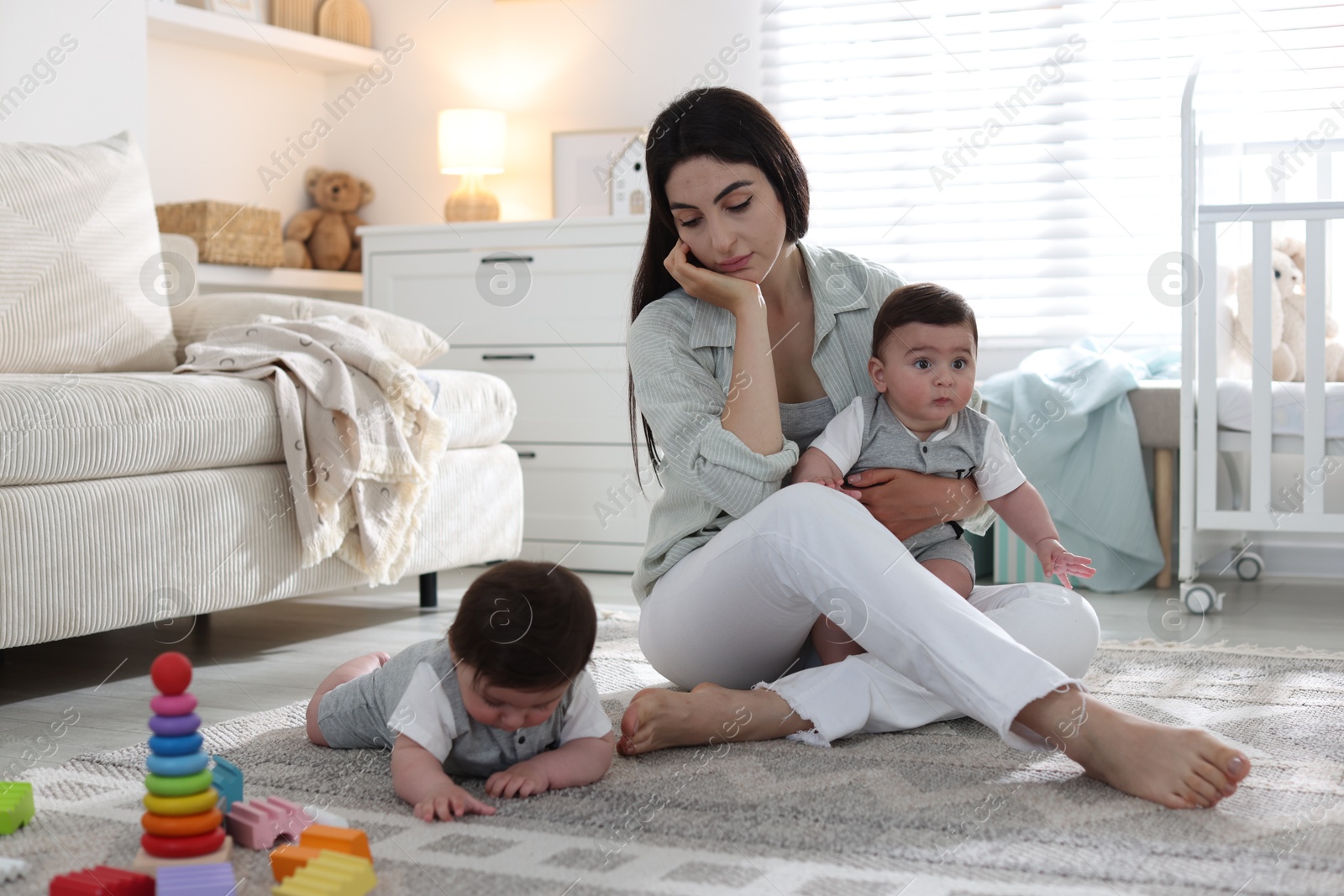 Woman suffering from postpartum depression with her little children at home Photo of Woman suffering from postpartum depression with her little children at home