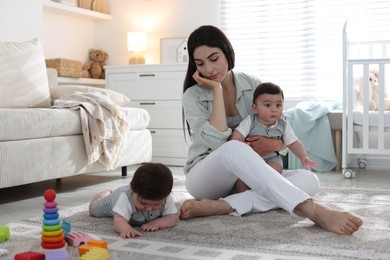 Photo of Woman suffering from postpartum depression with her little children at home