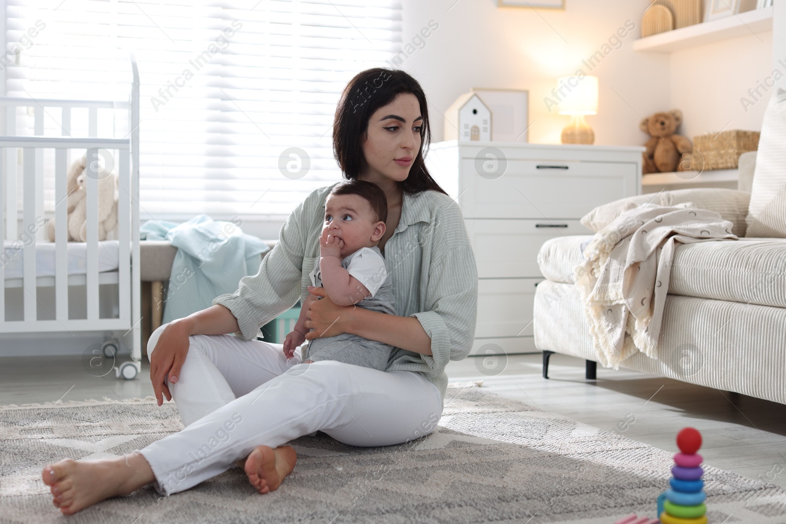 Woman suffering from postpartum depression with her little baby at home Photo of Woman suffering from postpartum depression with her little baby at home