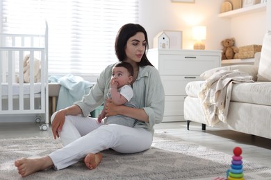 Photo of Woman suffering from postpartum depression with her little baby at home