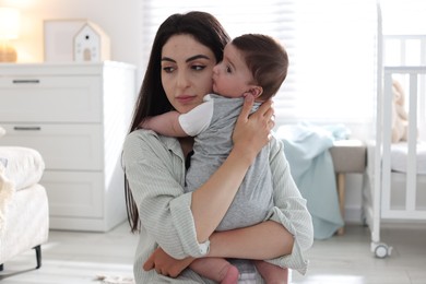 Photo of Woman suffering from postpartum depression with her little baby at home
