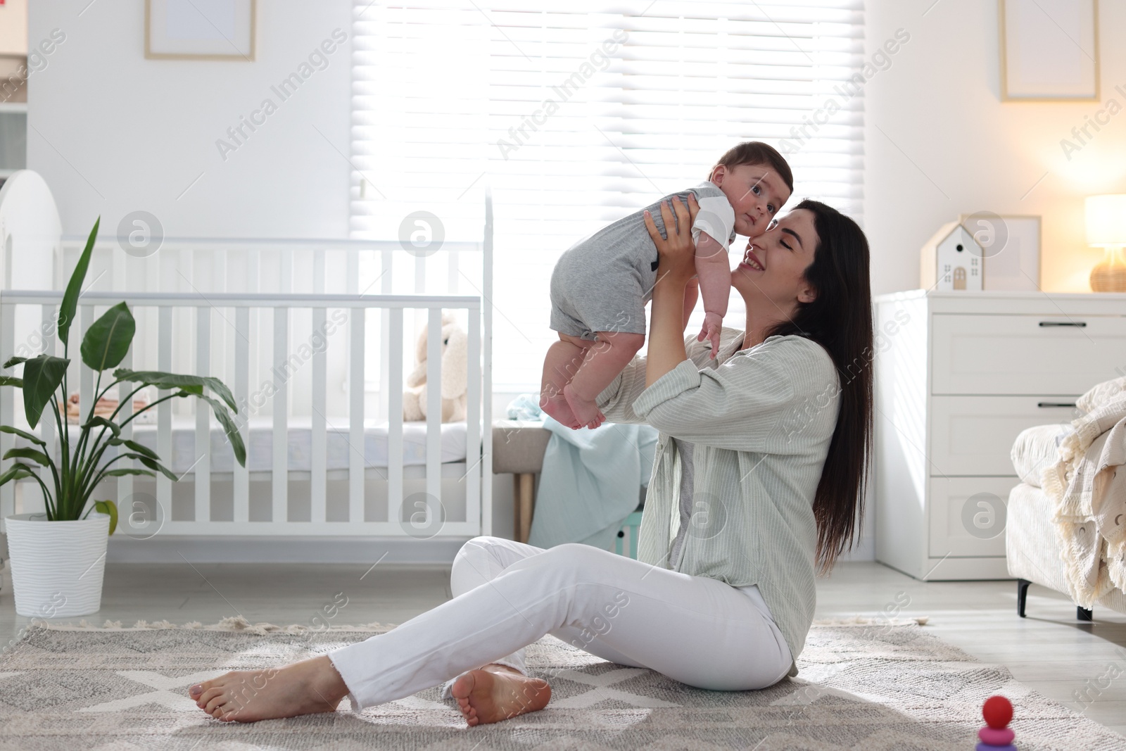Mother with her cute baby at home. Space for text Photo of Mother with her cute baby at home. Space for text