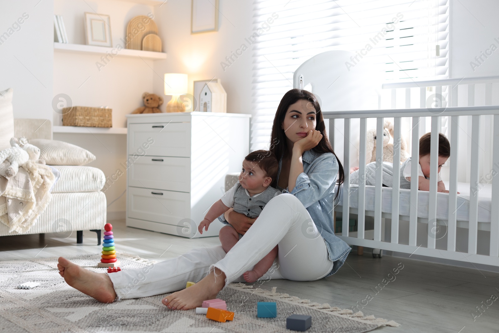 Woman suffering from postpartum depression with her little children at home. Space for text Photo of Woman suffering from postpartum depression with her little children at home. Space for text