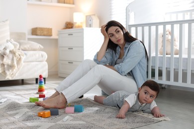 Photo of Woman suffering from postpartum depression with her little baby at home