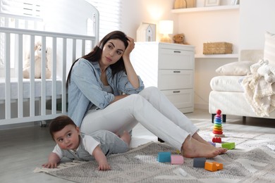 Photo of Woman suffering from postpartum depression with her little baby at home