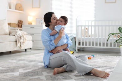 Photo of Mother kissing her cute baby at home