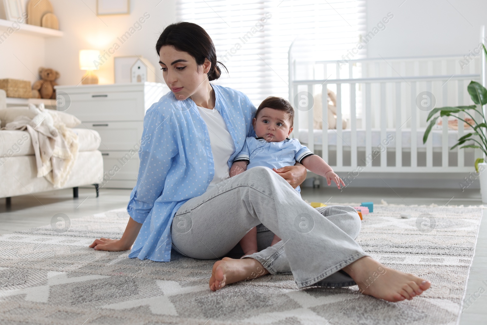 Woman suffering from postpartum depression with her little baby at home Photo of Woman suffering from postpartum depression with her little baby at home